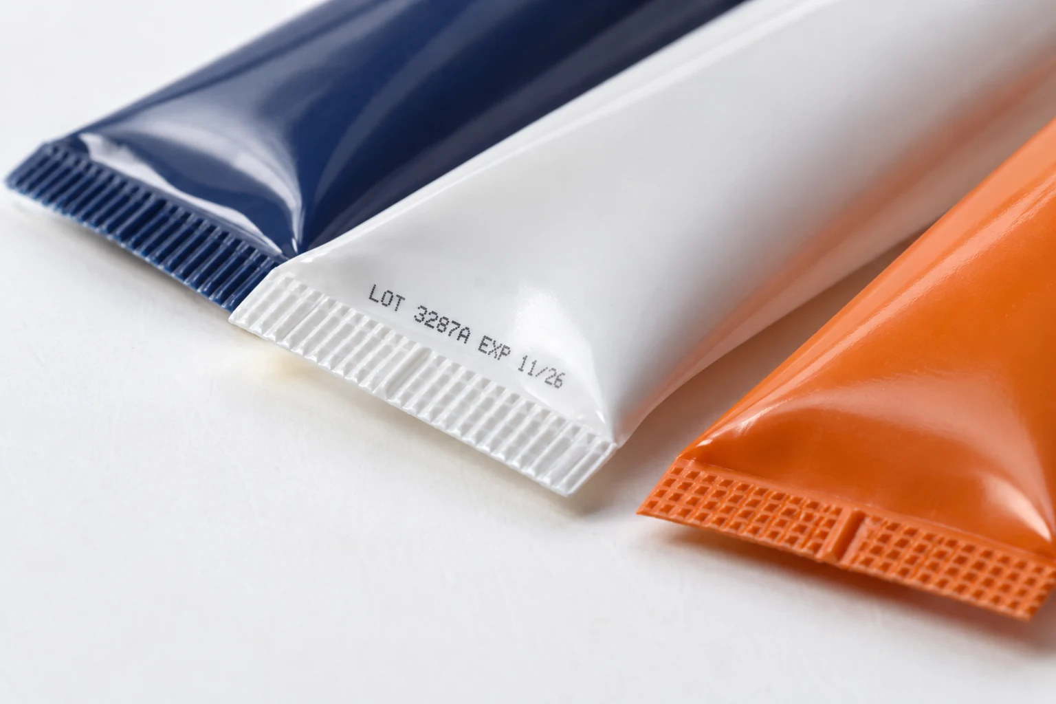 Close-up of real heat-sealed plastic tube tails and batch coding